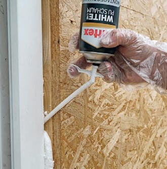 Isolert anneks: Skum i fuge i isolert anneks Isolert anneks: Det fylles skum i fugen rundt rammen til døren i det isolerte annekset